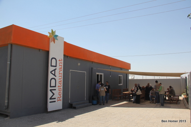 Aid workers outside the cafeteria in the secure base camp area which houses NGOs .